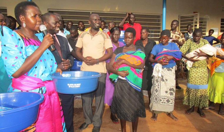 Akello Lucy and Gilbert olanya giving basins and bar of soap to mothers who give birth from Labongogali health centre
