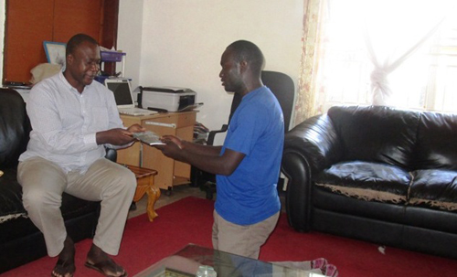 Ojok James Onono hands a copy to Acholi Paramount Chief