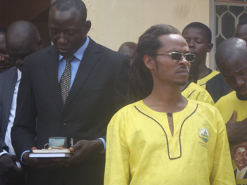 Rasta Guwan, behind him is Gulu RDC Andrew Awany