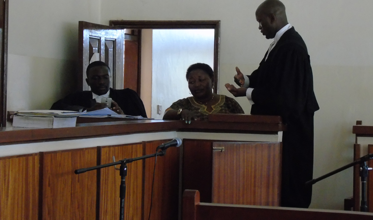 Jane Frances Amongin Okili, former Amuru District Woman MP Aspirant (C) consults her Lawyer Andrew Mauso on Tuesday at Gulu High Court