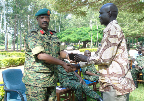 Brig. Kayanja Muhanga, the 4th Division Army Commander handing Certificates to retired army officers during a ceremony at Gulu Army Barracks on Friday
