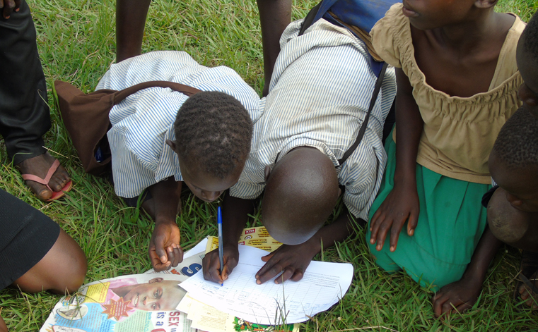 Children signs for copies of Young Talk during the African Child Day commemoration in Gulu on Tuesday at Bobi Sub County. Photo by James Owich