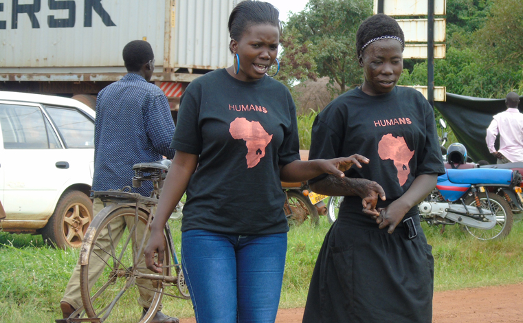 Ketty Adoch, 17, a Nodding Syndrome sufferer (L) having light moment with Christine Apio (R), the Communications Officer for Hope for Humans, a local NGO supporting children affected by Nodding Syndrome on Tuesday in Gulu. Photo by James Owich