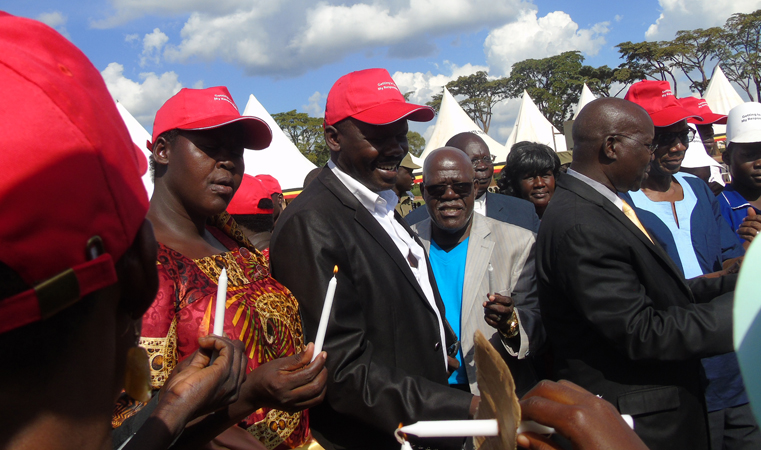 Caption: (Prof. Vinard Nantulya, Chairman Board Uganda Aids Commission (L) and Ethics Minister Fr. Simon Lukodo (R) in red cap prepare to Light Candle during the International Candle Light Memorial Day last Friday in Gulu town. Photo by James Owich)