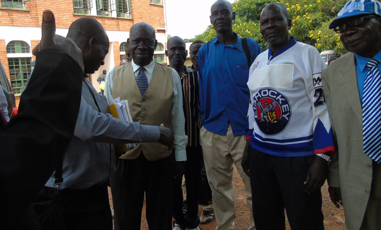 Parish Chiefs Smile outside Gulu High Court buildings after court attaches Gulu District Local Government Bank Accounts to clear their Debts 