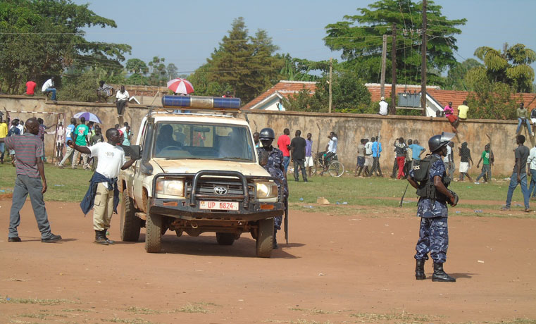 Unidentified crime preventer directs police patrol during a riot at Pece War Memorial Stadium in Gulu town in July 2015 during Secondary School Athletics Champions