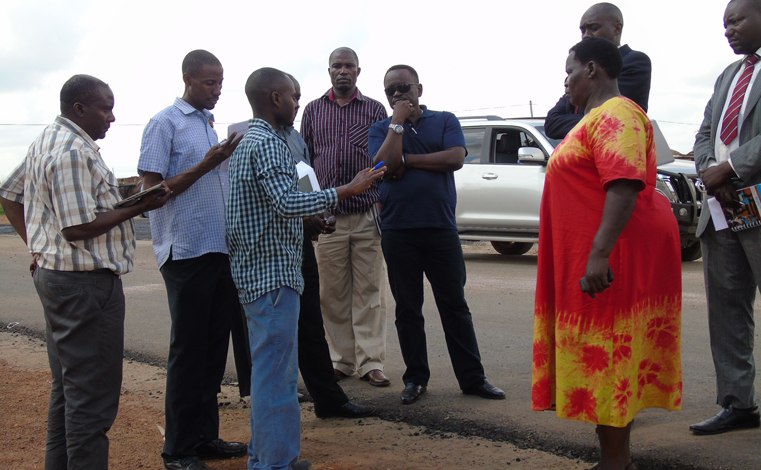 Gabindadde  Musoke (in blue t-shirt and dark shades, the Permanent Secretary, Ministry of Lands, Housing and Urban Development accompanied by Gulu Municipal Council and CHICO officials touring road projects funded by World Bank in Gulu Municipality on Tuesday