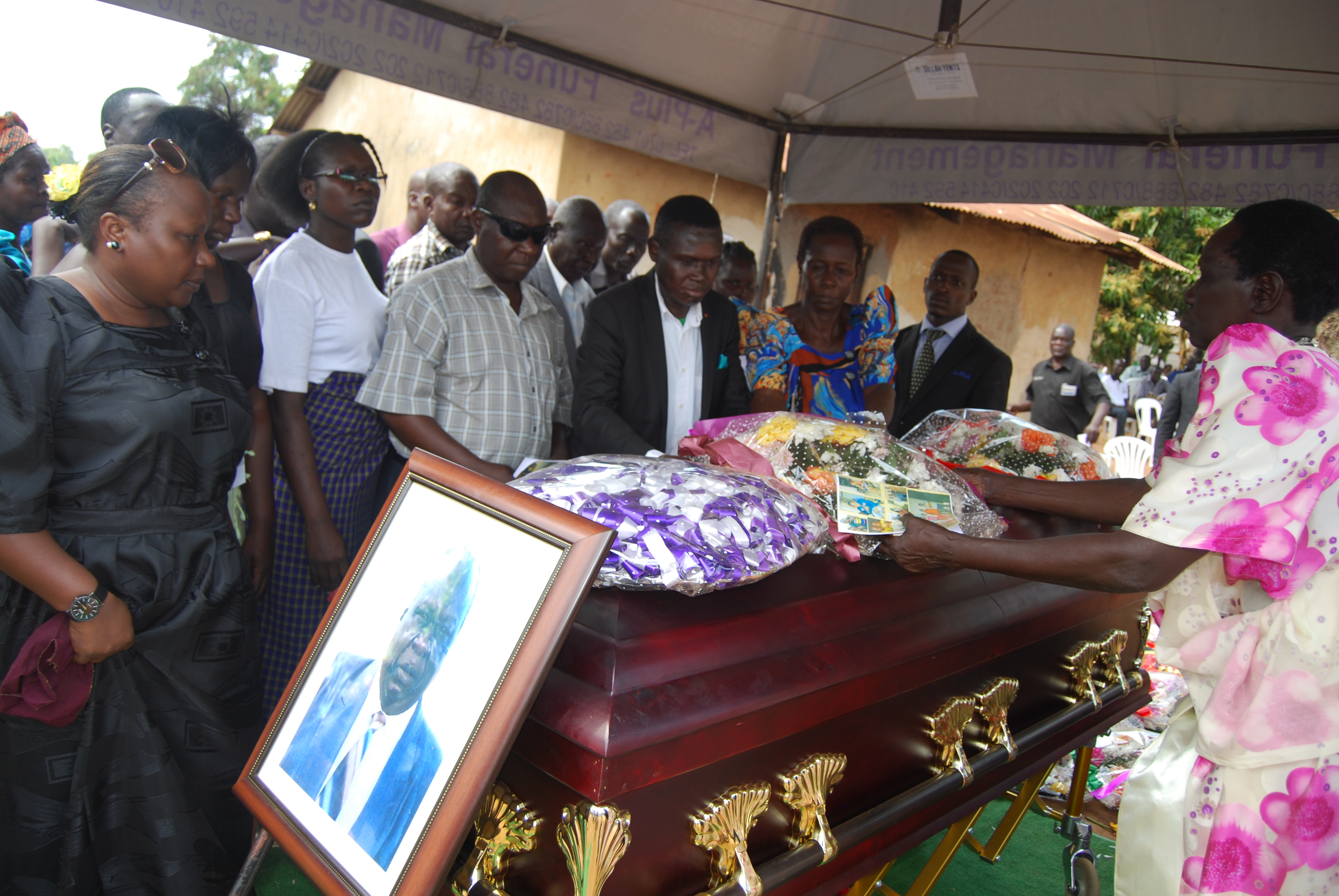 Mao and relatives lay wreath on the casket of his late father Dusman Okee