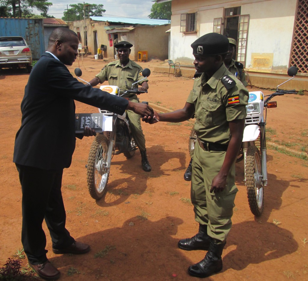 Francis Engwau from UNFPA handing over keys of the motorcycles to O/C station Edwin Antukunda at CPS Gulu